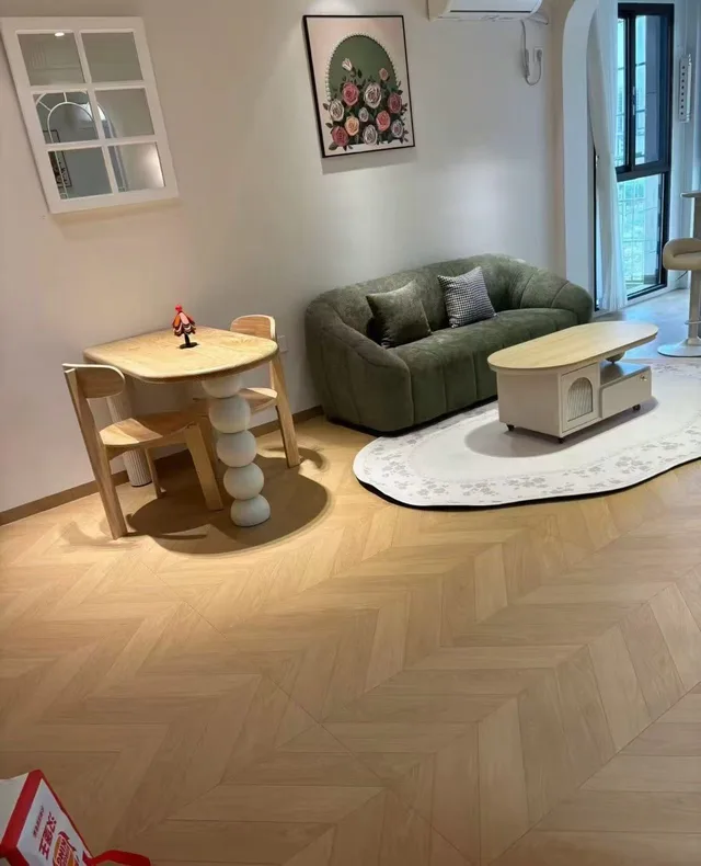 Living room with a green sofa and a warm patterned floor