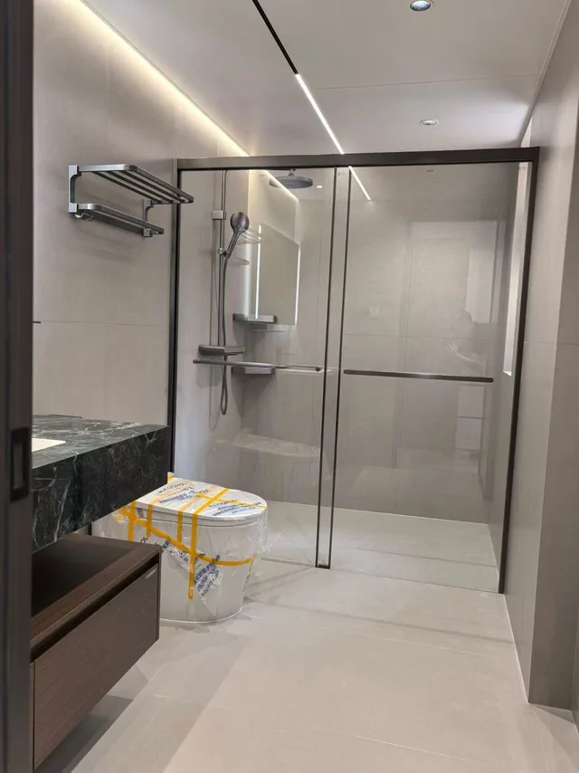 Bathroom showroom with a glass shower enclosure and wall-mounted fittings
