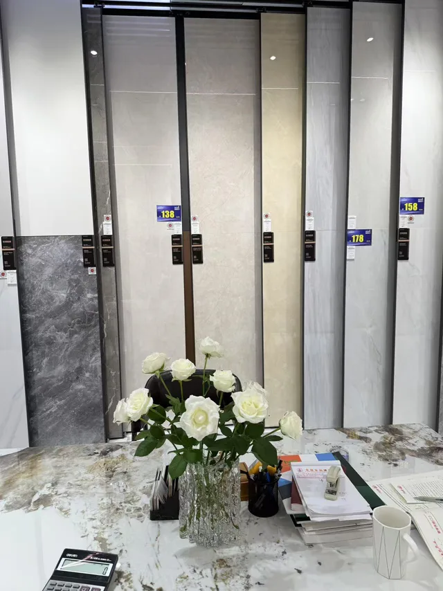 Tall pale stone-pattern panels behind a showroom table
