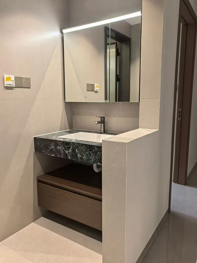 Side view of a basin cabinet with a mirror and drawer storage