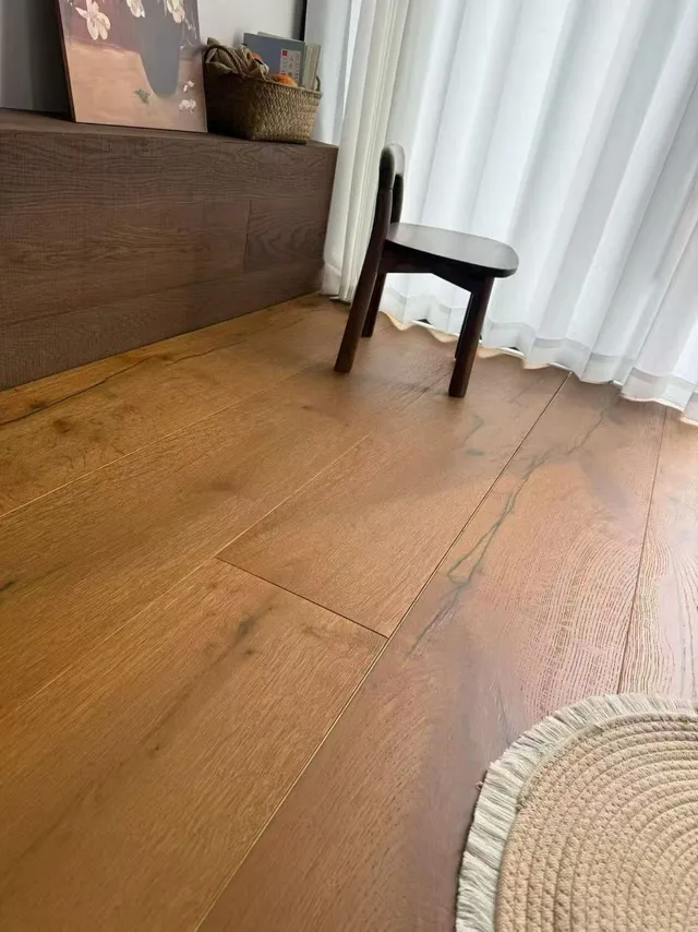 Close view of a warm wood-tone floor beside a curtain and chair